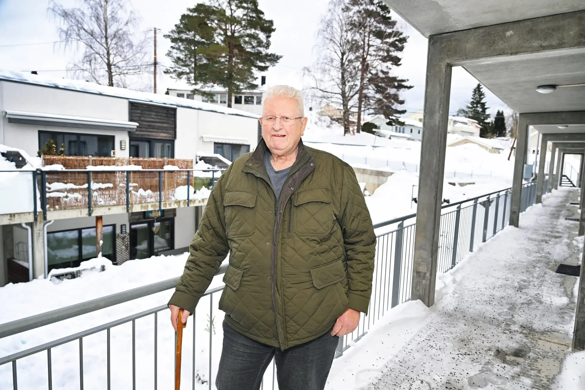 Mann ute foran bolig på vinteren.