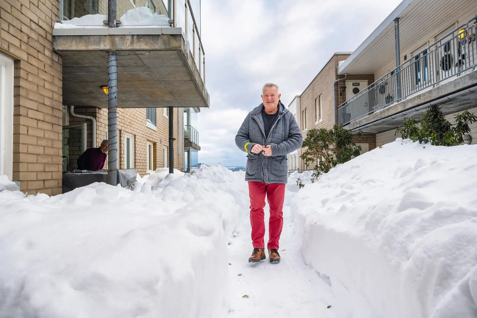 Mann gående ute mellom bygg om vinteren